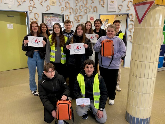 Eine Gruppe von Schulsanitätern hält Schilder hoch und zeigt ihre Unterstützung für eine gemeinsame Sache.