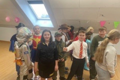 Eine Gruppe von Kindern in Kostümen steht fröhlich in einem Raum.