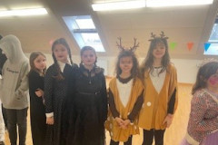 Eine Gruppe von Kindern in bunten Kostümen, die fröhlich zusammensteht und lächelt.