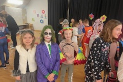 Kinder in Halloween-Kostümen feiern fröhlich auf einem Schul-Event.